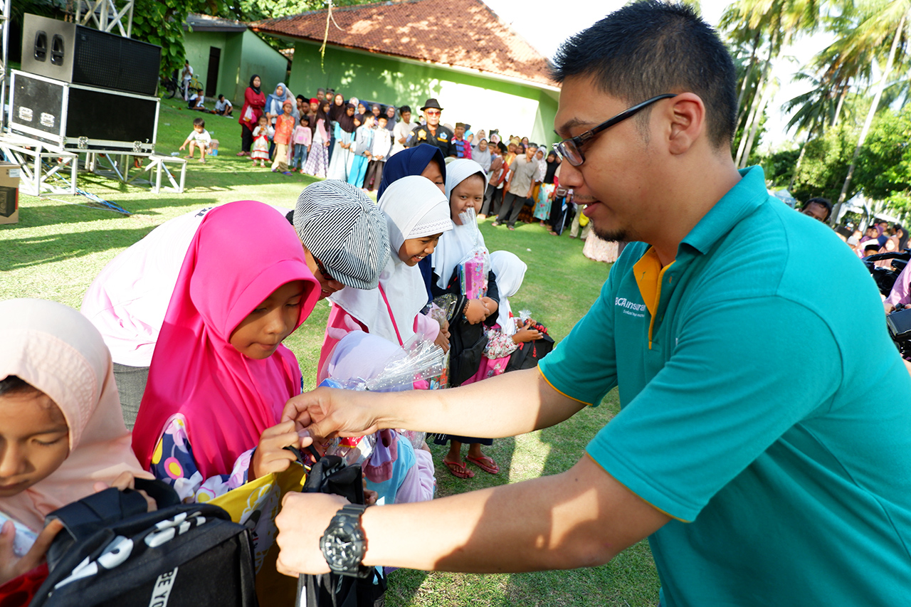 Bapak Barata selaku perwakilan dari BCAinsurane memberikan alat tulis dan tas kepada anak-anak yatim piatu di acara Anyer Urban Festival 2019.